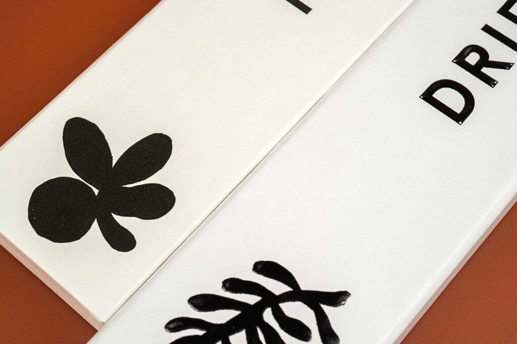 Two rigid boxes with slightly different colored box wraps. The one on the right is in white and the left one is in an eggshell color.